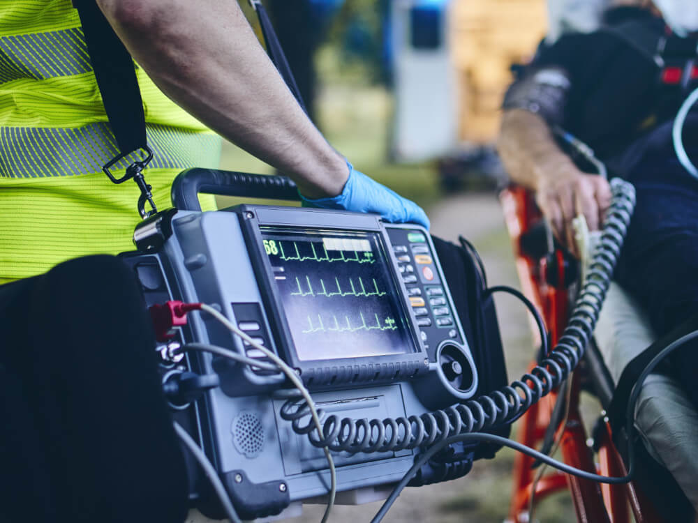 Mobiler Patientenmonitor Ein Sanitäter auf einem Einsatz – er trägt einen mobilen Patientenmonitor
