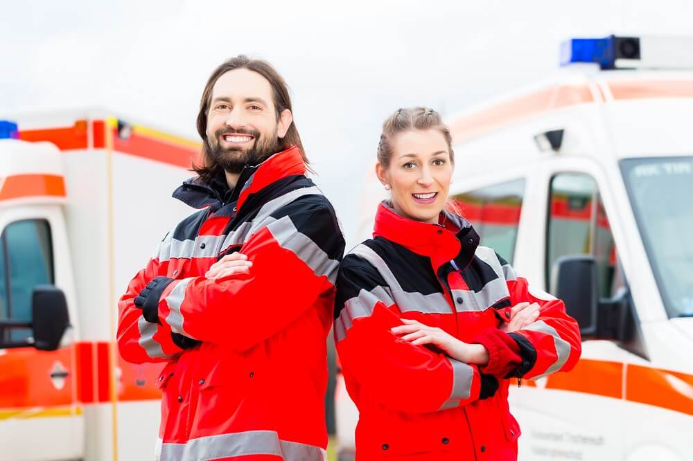 Produkte für die Notfallversorgung Ein Rettungssanitäter und eine Rettungssanitäterin freuen sich über die Produkte zur Notfallversorgung.