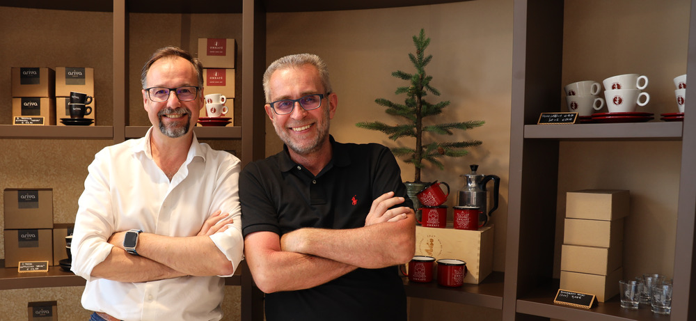 Walter Gefäll und Lorenzo Martinelli — Geschäftsführer von Omkafe — im Showroom der Rösterei in Arco Walter Gefäll mit Lorenzo Martinelli, Geschäftsführer der Rösterei Omkafe, im Showroom in Arco vor dem Sortimentsregal