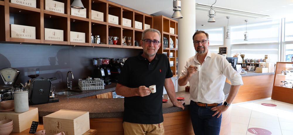 Walter Gefäll und Lorenzo Martinelli — Geschäftsführer von Omkafe — bei einem Espresso an der hauseigenen Bar in Arco Walter Gefäll und Lorenzo Martinelli mit Espresso-Tasse an der hauseigenen Bar von Omkafe in Arco