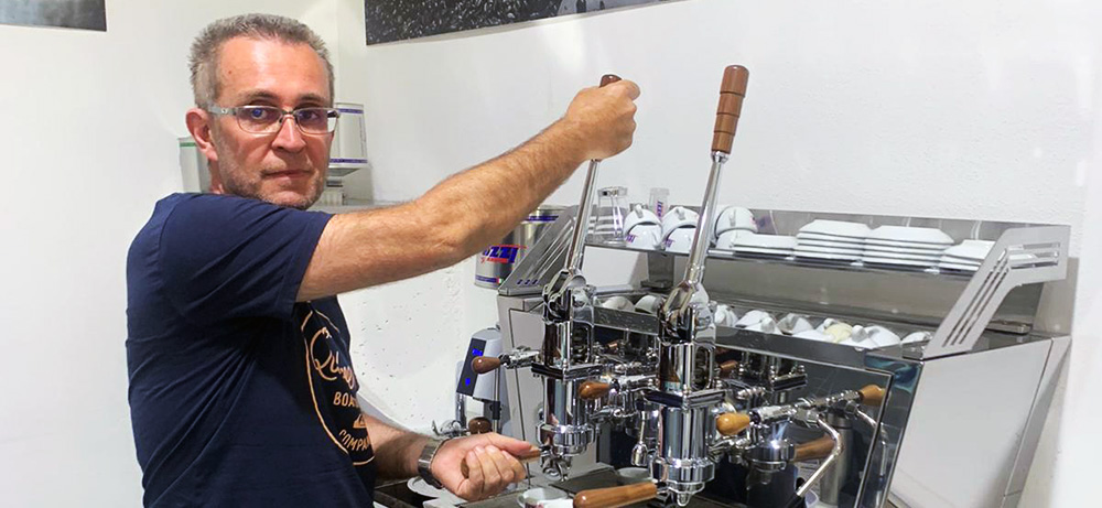 Walter an der Hebelmaschine Walter Gefäll zieht an einer verchromten Hebel-Espressomaschine einen Espresso