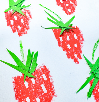 Karte mit Erdbeermotiv als Nahansicht. Die Erdbeeren wurden mit Wachsmalstiften und einem Marker gemalt und mit grünen Papierschnipseln dekoriert.