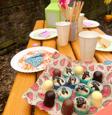 Sommerlich gedeckter Tisch. Im Vordergrund sind Muffins und Schaumküsse zu sehen.