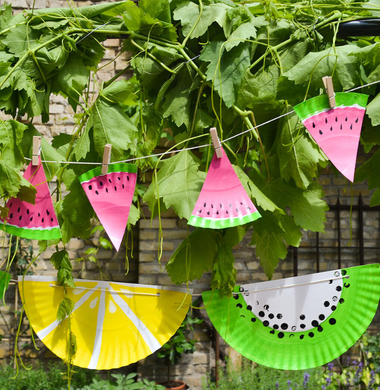 Gebastelte Sommergirlande aus Papptellern, die wie Melonen angemalt sind.