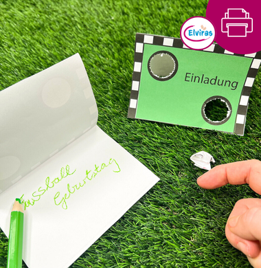 Eine gebastelte Einladungskarte zum Thema "Fußball". Auf der Vorderseite ist ein Fußballtor abgebildet, durch das man zwei Löcher schneiden kann. Das Papier, das man rausschneidet kann man zu einem Ball zusammenknüllen und es mit den Fingern durch das Torloch schnippen.