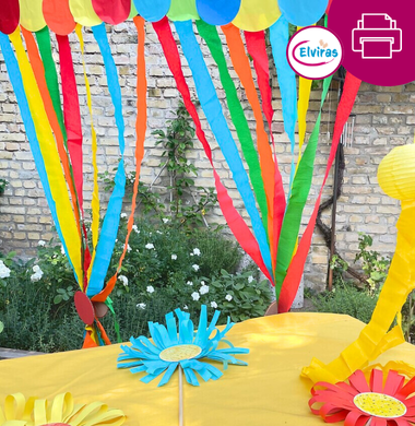Sommerliche Dekoration: Ein Tisch mit gelber Tischdecke und gebastelten Blumen und einer Krepppapiergirlande.