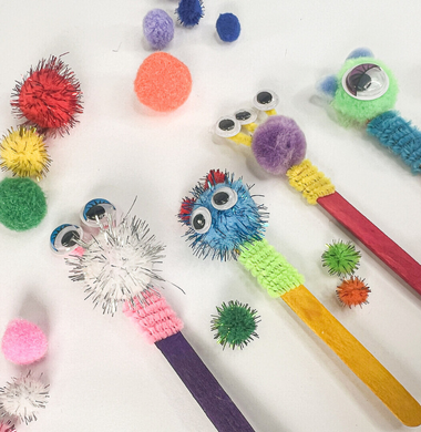 Holzstäbchenmonster aus bunten Holzstäbchen, Wolle, Glitzer-Pompons und Wackelaugen.