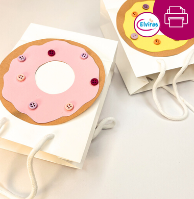 Zwei Papiertragetaschen, die mit Tonpapier beklebt sind. Ein riesiger Donat aus Tonpapier und kleinen Knöpfen, die als Verzierung dienen.