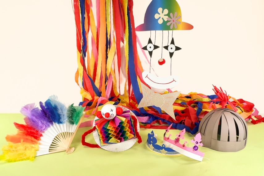 Ein Bild mit vielen Basteleien zum Thema Fasching. Viel Krepppapier, mehrere gebastelte Clowns und Kronen.