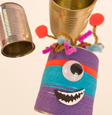 Gebastelte Dosenmonster aus einer Konservendose, die mit Wolle umwickelt wurde, einem großen Wackelauge, Fühlern aus Chenille und je einem Pompon und einem Moosgummimund.