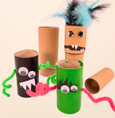 Monster aus bemalten Papprollen, die mit Chenille, Wackelaugen, Federn und Papier geschmückt sind.