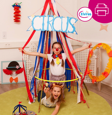 Zwei Mädchen spielen in einem gebastelten Zirkus-Zelt. Dieses besteht aus Krepppapierstreifen, die an der Decke hängen und unten an einem Hula Hoop Reifen befestigt. Oben hängt ein Schild mit der Aufschrift "Circus", welches bei uns als Bastelvorlage heruntergeladen werden kann.