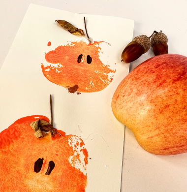 Apfeldrucke. Eine Apfel halbieren und mit Farbe bestreichen. Jetzt auf Papier drucken und bemalen und verzieren.