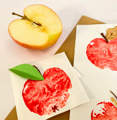 Apfeldrucke. Eine Apfel halbieren und mit Farbe bestreichen. Jetzt auf Papier drucken und bemalen und verzieren.