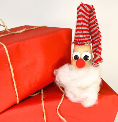 Ein Nikolaus aus einem Papp-Kegel, welcher mit einem Wattebart, einer Pomponnase, Wackelaugen und einer gestrickten Mütze geschmückt ist.