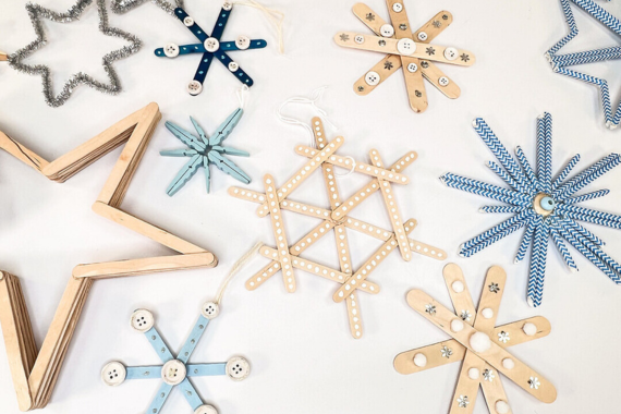 Viele gebastelte Schneeflocken. Aus Strohhalmen, Pfeifenputzern, Wäscheklammern und Holzstäbchen.