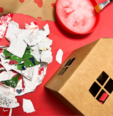 Für die Wichtelhäuschen die Geschenkpapierreste zerkleinern und mit Kleister auf das Papphäuschen kleben.