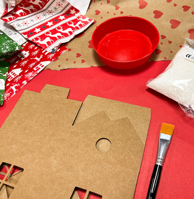 Materialien für die Wichtelhäuschen: Papphäuschen, Geschenkpapierreste und Kleister.