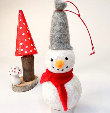 Ein Schneemann aus zwei Pappmache-Kugeln, die bemalt und aneinander geklebt wurden. Geschmückt mit einer Filzmütze und -schal.