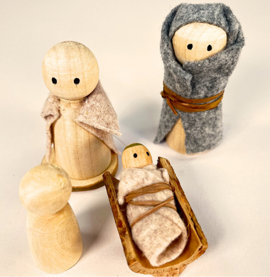 Mehrere Holzfiguren, gekleidet in Bastelfilz. Sie stellen Jesus, Maria und Joseph dar.