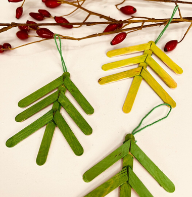 Ein Tannenbaum aus angemalten und zusammengeklebten Holzstäbchen.