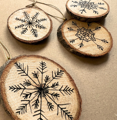 Bemalte Holzscheiben. Im Inneren wurde mit einem dünnen Fineliner eine Schneeflocke gemalt.