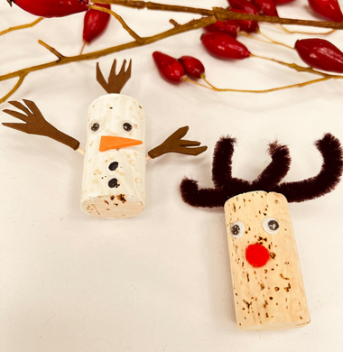 Ein Schneemann  und ein Rentier aus einem angemalten Bastelkorken, Wackelaugen, Tonpapier und Armen aus Schaschlikspießen.