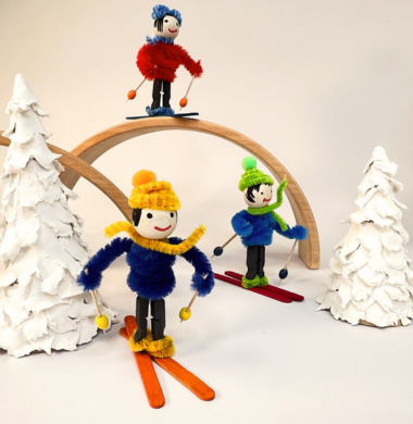 Gebastelte Skifahrer aus Holzkugel-Köpfen, Chenille-Körpern und Skiern aus Holzstäbchen.