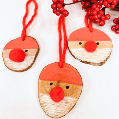 Nikoläuse aus Holzscheiben. Das innere der Holzscheibe wurde zu einem Nikolausgesicht bemalt. Die Nase ist ein roter Pompon.