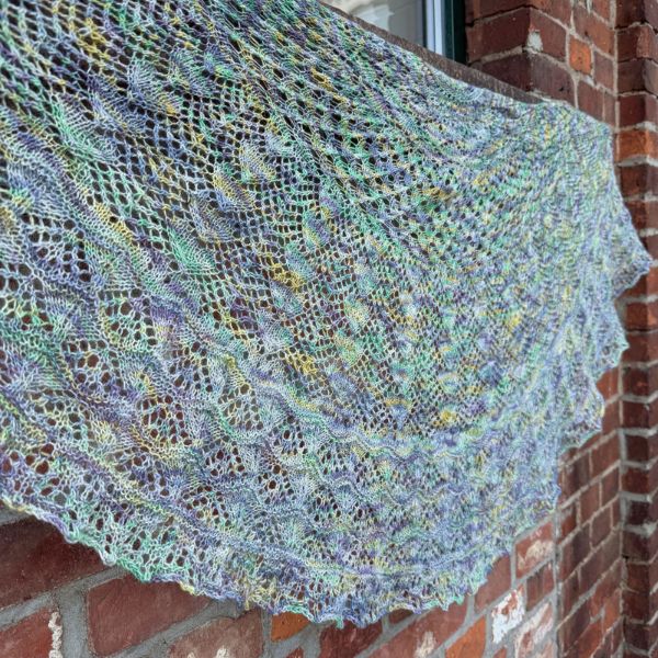 Halbrundes Tuch mit verschiedenen Mustern unter anderem Herzen gestrickt aus handgefärbten Alpaka Garn in den Farben grau, lila, grün und gelb.