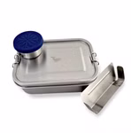 Silberne Edelstahl-Lunchbox mit herausnehmbarem Trennsteg und kleinem runden Saucenbehälter mit blauem Silikondeckel auf hellem Hintergrund.