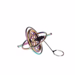 Der Moulin Roty Drehkreisel ist ein metallisches Kreiselspielzeug mit schillernder Oberfläche kreisförmigen Ringen und einer Schnur mit einem Zugring aus Metall dargestellt auf weißem Hintergrund.