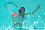Ein Schwimmer mit Schwimmbrille spielt unter Wasser in einem Pool und fängt einen Ball mit dem Schildkröt Neopren Diving Game Catch Netz. Das klare blaue Wasser unterstreicht den Spaß und in der Ecke ist das Schildkröt-Logo zu sehen.