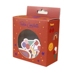 Eine rote Schachtel mit der Aufschrift "Tischkonfetti Sunny and Friends zur Einschulung" von AVA & YVES hat ein rundes Fenster mit buntem Konfetti und zeigt verspielte Illustrationen wie Kirschen einen Regenbogen ein lächelndes Gesicht und eine Eiswaffel.