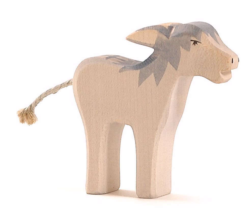 Ostheimer Ostheimer Esel störrisch Ahorn_27089 Der Ostheimer Esel störrisch Ahorn von Ostheimer ist eine Eselfigur aus hellem Holz mit grau bemalten Details und einem kurzen geflochtenen Seilschwanz dargestellt auf weißem Hintergrund.