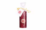 Karl Schubert Gemeinschaft Rote Stumpenkerze 12 cm Ø 5 cm aus Bienenwachs_32793 Eine 12 cm hohe und 5 cm breite rote Bienenwachskerze der Karl Schubert Gemeinschaft verpackt in durchsichtigem Plastik mit einem gelben gewellten Band und einem weißen Anhänger der auf der Vorderseite ein rundes goldenes Etikett mit rotem Text trägt.