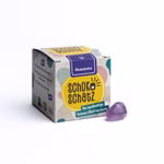 Die SchokoSchatz für Kids BIO Edition "Glückssteine" von SchokoSchatz zeigt ein Schokoladenei einen lila Edelstein und eine Box mit deutschem Text und bunten Motiven auf weißem Hintergrund.