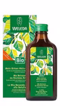 Ein brauner Weleda Birken Aktiv-Getränk-Glasflakon steht vor seiner grün-weiß beblätterten Verpackung. Sowohl das Etikett als auch die Verpackung enthalten mehrsprachige Produktinformationen wobei "Bio" hervorgehoben wird um die natürlichen Eigenschaften z