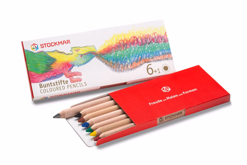 Stockmar STOCKMAR Bunstifte dreieckig 6+1 6 Farben plus 1 Bleistift_33475 Eine rote Schachtel mit STOCKMAR Bunstifte dreieckig 6+1 von Stockmar teilweise geöffnet um sieben Bleistifte zu enthüllen. Die Verpackung zeigt einen bunten Drachen und die Aufschrift "Bunstifte dreieckig 6+1" mit 6 Farben plus 1 Graphitstift.