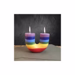 Die "Kerze in U-Form multicolor" von Himalaya Salt Dreams zeigt zwei Flammen und horizontale Regenbogenstreifen auf einer grauen Oberfläche mit einem dunkel strukturierten Hintergrund.