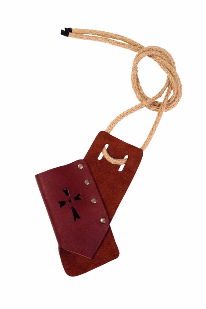 Spielzeugmanufaktur VAH Schwert-/Axthänger Thilo Leder_34144 Der Schwert-/Axthänger Thilo Leder von der Spielzeugmanufaktur VAH ist eine handgefertigte braune Ledertasche mit Metallnieten und einem schwarzen Kreuzmotiv das an einem dicken hellbraunen Seil befestigt ist abgebildet auf weißem Hintergrund.