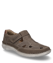 The brown leather shoe features a practical Velcro closure and distinctive cut-out details on the sides. The light sole and padded collar provide additional comfort.