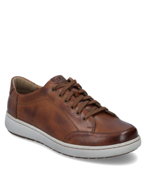 The sneaker in cognac combination features a smooth leather upper with light stitching and a sturdy white rubber sole. Notable features include the brown laces and the subtle seam detailingwhich give the shoe an elegant look.