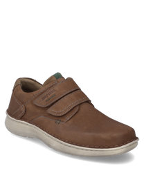 Der Halbschuh aus braunem Leder hat einen praktischen Klettverschluss. Die helle Sohle bietet einen angenehmen Kontrast während die feinen Nähte dem Schuh eine elegante Note verleihen.
