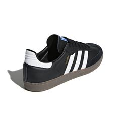 Der Sneaker besticht durch sein klassisches Design in Schwarz mit weißen Streifen. Er besteht aus Leder und Wildleder mit einer hellbraunen Gummisohle für optimalen Halt.