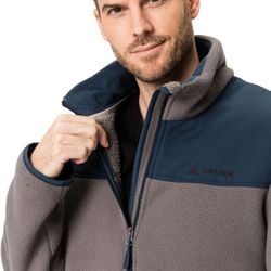 Die abgebildete Fleecejacke ist grau mit dunkelblauen Schulterpartien und einem durchgehenden Reißverschluss. Das weiche Fleece-Material bietet Wärme und Komfort ideal für kühle Tage.