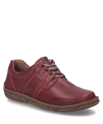 El zapato de media altura en color burdeos de cuero se caracteriza por su robusto cordón y la costura distintiva a lo largo de los lados. La suela está hecha de un material duradero y ofrece comodidad adicional al usarlo.