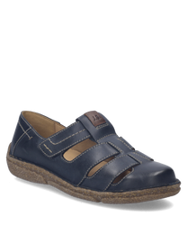 Zapato bajo de cuero azul con cierre de velcro. Suela marrón y costuras visibles aportan un toque artesanal.