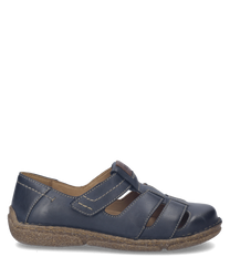 Zapato bajo de cuero azul con cierre de velcro. Suela marrón y costuras visibles aportan un toque artesanal.