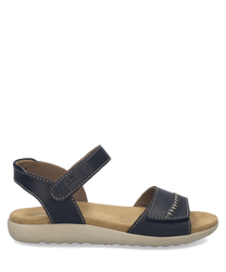 Schwarze Sandale aus Leder mit Klettverschluss. Sie besitzt eine bequeme beige Sohle und sichtbare Nahtdetails auf den Riemen.